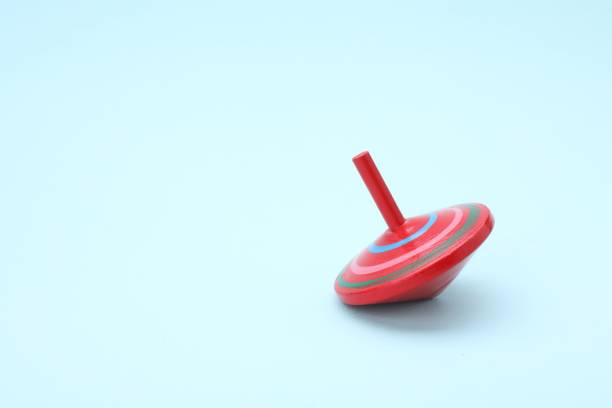 istock One bright spinning top on light blue background, space for text. Toy whirligig 1902988545