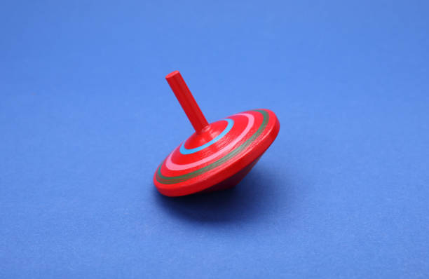 istock One bright spinning top on blue background. Toy whirligig 1902990665