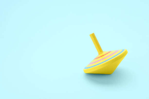 istock One bright spinning top on light blue background, space for text. Toy whirligig 1902991174