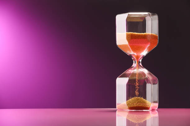 istock Hourglass with flowing sand on color background. Space for text 1902991362