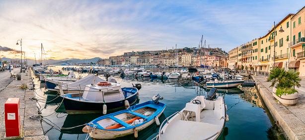 Beautiful Mediterranean Village Harbor with sailing and fishing boats,  Portoferraio in Elba, Italy. Sunlight in the back and shiny water.