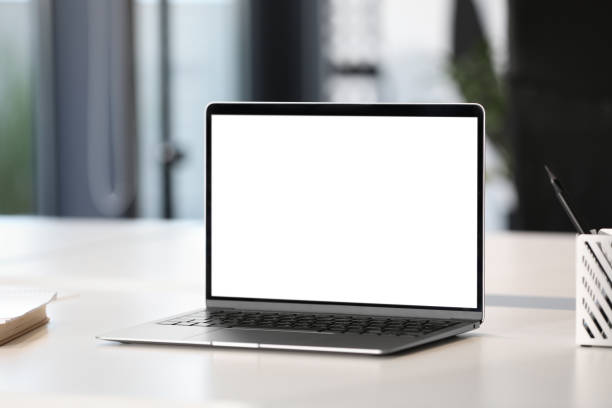 istock Modern laptop on white desk in office. Mockup for design 1902996621