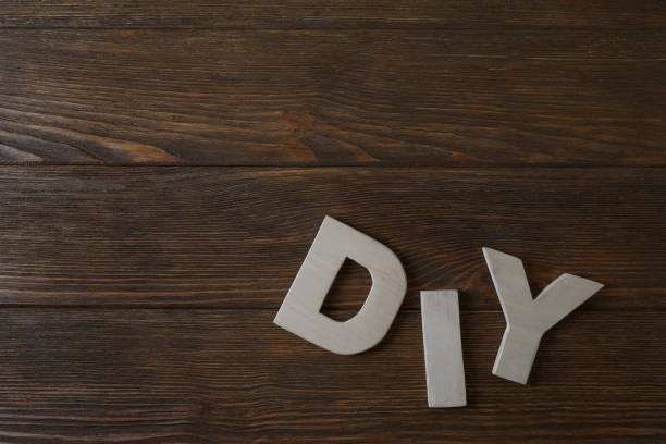 istock Abbreviation DIY made of letters on wooden table, flat lay. Space for text 1902996855