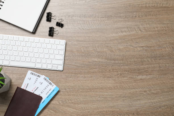 istock Flat lay composition with tickets, passport and keyboard on wooden table, space for text. Business trip 1902996861