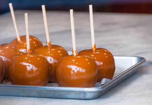 A tray of freshly made candy apples cool on a metal tray in a candy store window in Brevard, North Carolina.