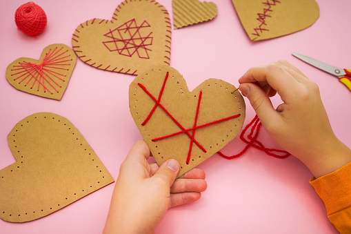 Step by step instruction: DIY gift for Valentine's Day. step 3 using a red thread and a needle, we make patterns.
