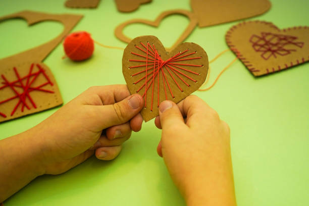 istock Kids hands hold paper heart. DIY gift for Valentine's Day. Zero waste. 1902997409