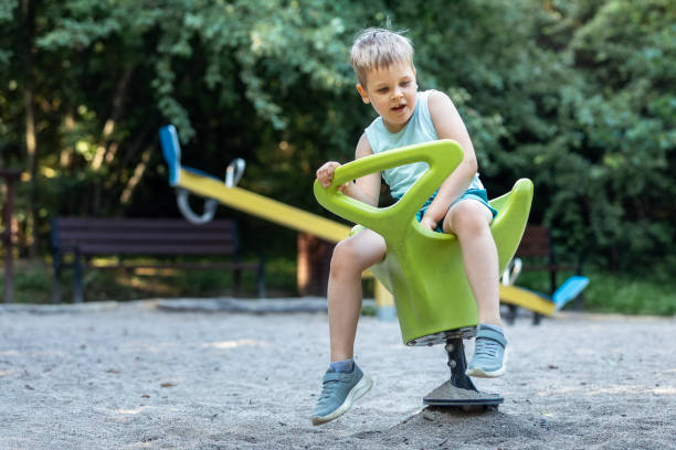 istock A smiling boy on a green spring ground swing in a playground 1903012981