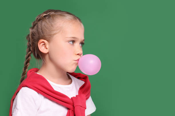 Happy girl with candy in living room, Asian kid girl eat sweet candy