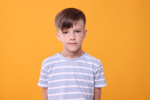 Portrait of cute boy on orange background