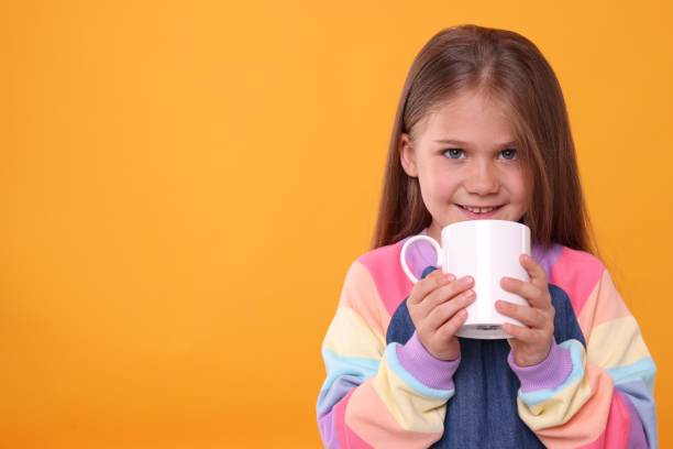 istock Happy girl with white ceramic mug on orange background, space for text 1903023892