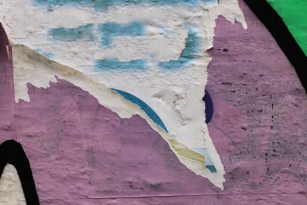 istock Pieces of torn paper peeling off wall used as billboard 1903082126
