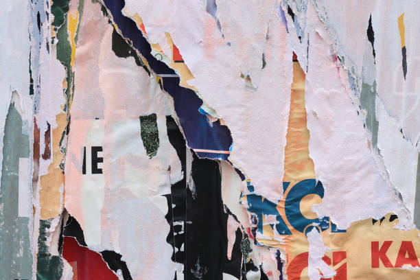 istock Pieces of torn paper peeling off wall used as billboard 1903082133