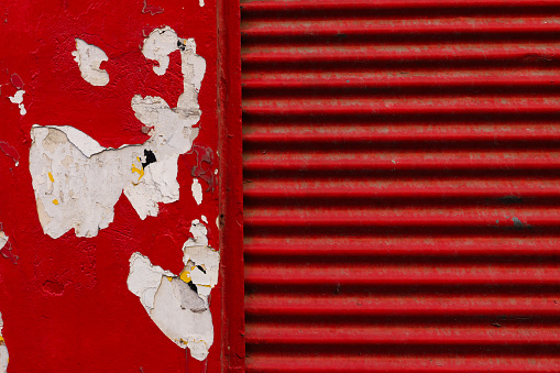 Old Red Wall With Flaked paint metal shop shutter closed