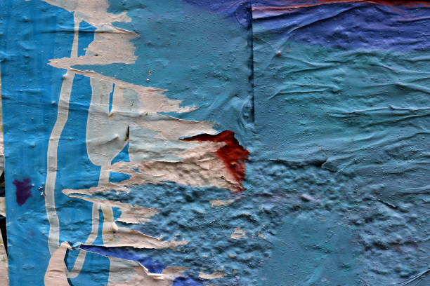 Torn paper collage background on an old poster on a street wall. Texture and surface of torn paper. High quality photo