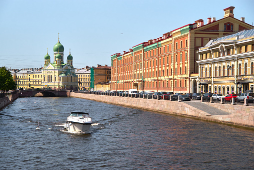 Cityscape of the street and water Griboedov canal with recreational boats, old residential multicolor buildings in the historical center of St. Petersburg, Russia.