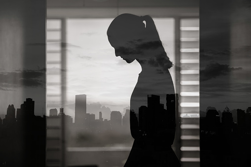 Businesswoman looking at city skyline through office window