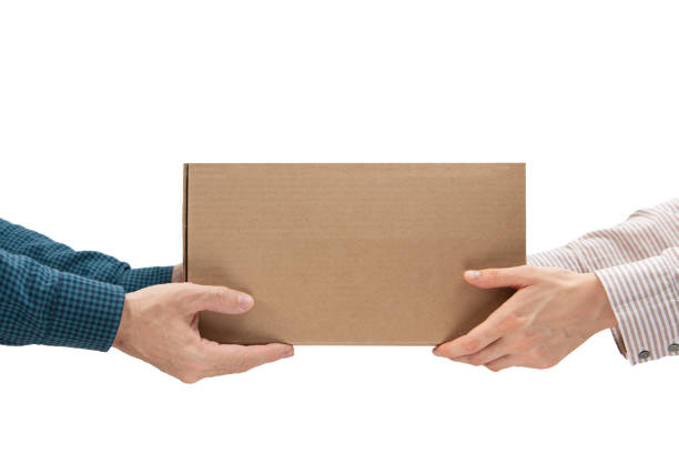 Male hands giving a package, female hands receiving a package stock photo
