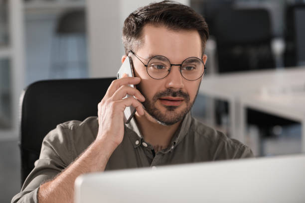 istock Man talking on smartphone at workplace in office 1903151083