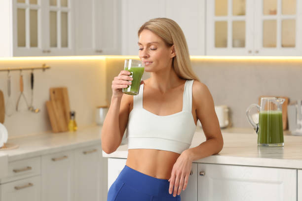 istock Woman drinking fresh celery juice in kitchen 1903153657