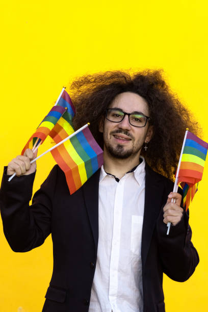 business man holding rainbow flag. man in formal suit holding rainbow flag isolated - homosexual gay pride business rainbow imagens e fotografias de stock
