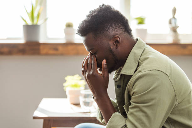 istock Shot of a man looking stressed while sitting on the sofa at home. 1903193945