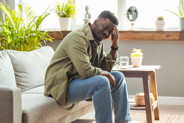 istock Frustrated middle aged man with hand on head sitting on couch at home. 1903193948