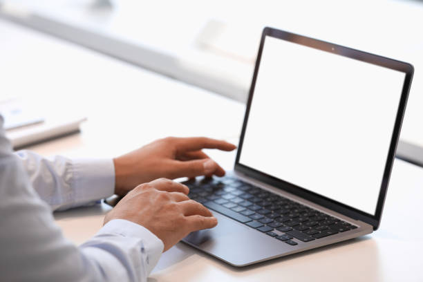 istock Man using modern laptop at white desk, closeup 1903213300