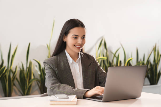 istock Happy woman using modern laptop at desk in office 1903214882