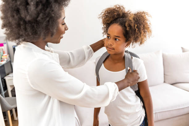 istock Mother preparing her daughter for first day in school. 1903250864