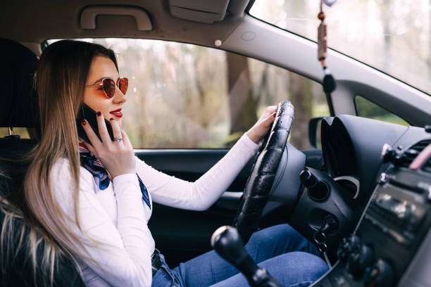 istock Attractive young girl talking on her mobile phone behind the whe 1903282407