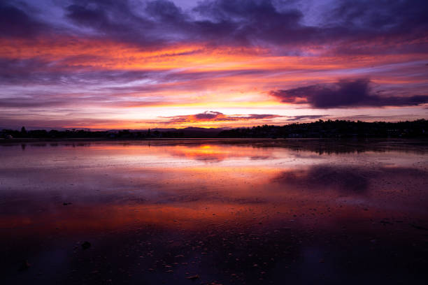istock Dramatic pinks and orange sunset colours offset by the black landscpae 1903282945