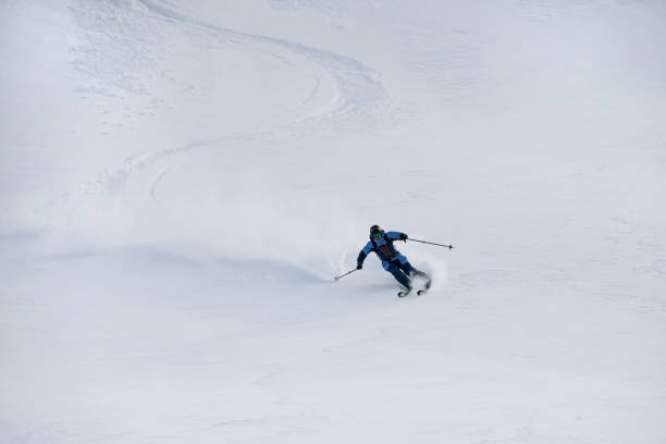 istock view on snowboarder riding down the untouched powder snow. 1903292151