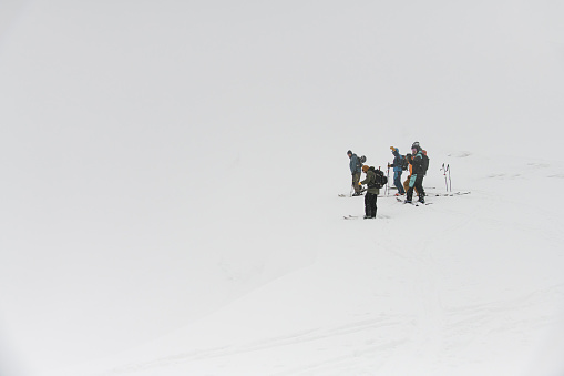 great view on group of travelers and ski tourists with backpacks on backdrop of white winter snowy mountains. Ski touring concept