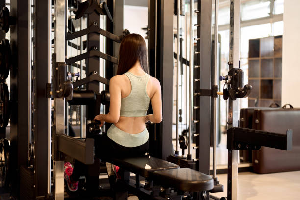 istock Woman training her back with cable rows at the gym 1903418550