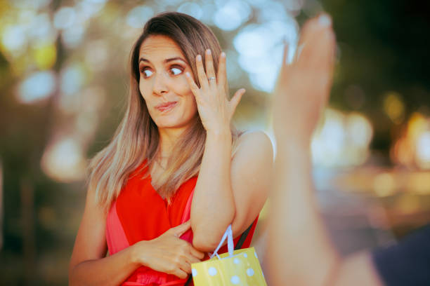Person Pretending Not to See Someone Waving and Saluting Woman disregarding a friendly greeting after recognizing an annoying acquaintance annoying mother in law stock pictures, royalty-free photos & images