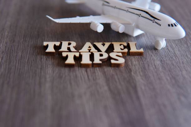 istock Toy plane and word TRAVEL TIPS on wooden table 1903536992