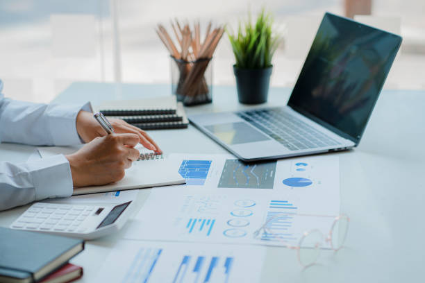 istock Accountant using calculator with laptop computer, budget and loan documents, Asian businesswoman meeting online to discuss project plans and financial results in office, close-up shot 1903538023