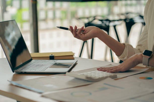 istock Accountant using calculator with laptop computer, budget and loan documents, Asian businesswoman meeting online to discuss project plans and financial results in office, close-up shot 1903538536