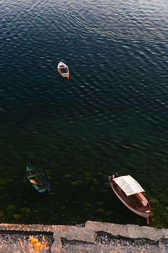 Boats parked in crystal-clear emerald-colored water in Ohrid, Municipality of Ohrid, North Macedonia