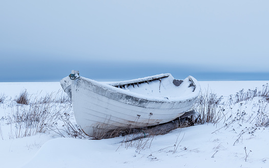 old wooden boat on a snowy shore in Hailuoto, North Ostrobothnia, Finland