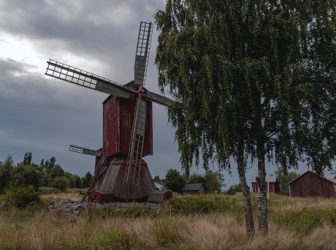 Old red wooden windmill, old red huts in the field in Molpe, Ostrobothnia, Finland