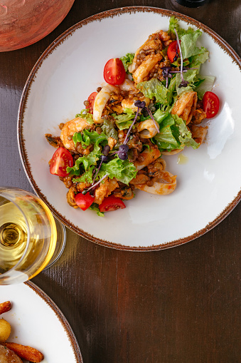 salad with seafood, vegetables and sauce on the table with a gla in Paris, Île-de-France, France