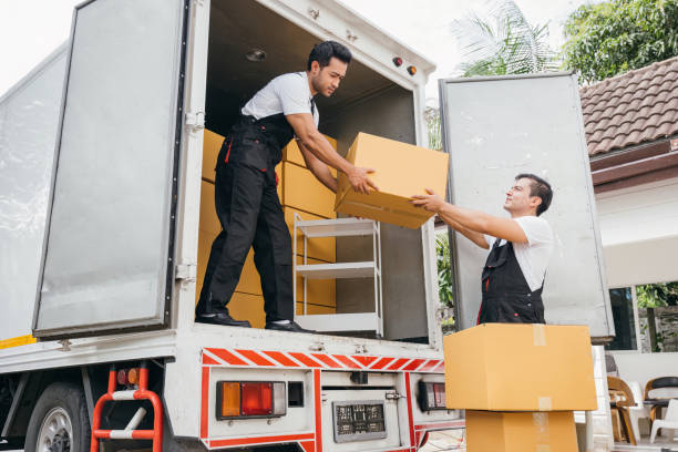 istock Workers in uniform exhibit teamwork unloading cardboard boxes from the moving truck for customer relocation. The company efficient service ensures a happy move. Moving Day 1903572405