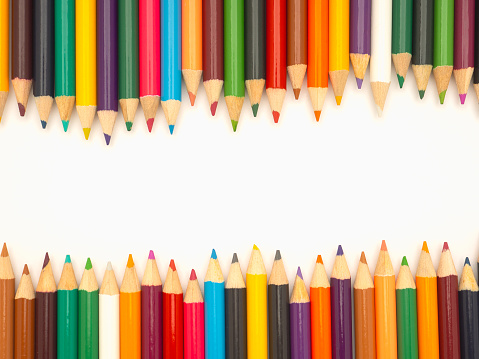 Close-up of colored pencils in a row on white background with copy space