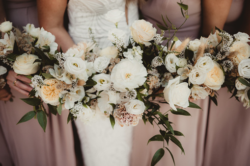 Bride and bridesmaids holding lush wedding flowers