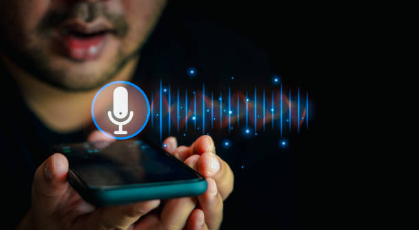 istock Man holding in hand smart phone talking with digital assistant or friend distantly uses easy voice messaging. 1903640133