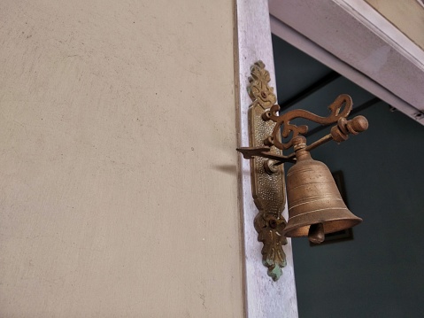 Close-up low-angle view of vintage bronze door bell with copy space