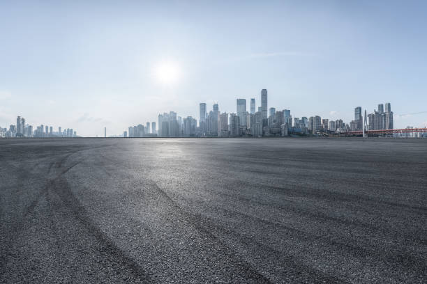 istock Empty asphalt road and city buildings skyline at sunset 1903675014