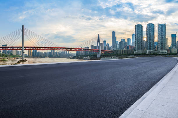istock Empty asphalt road and city buildings skyline at sunset 1903678604